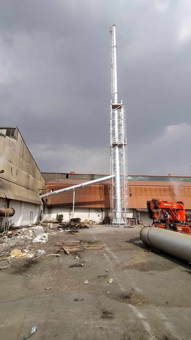 Chimney stack erected beside a factory shed