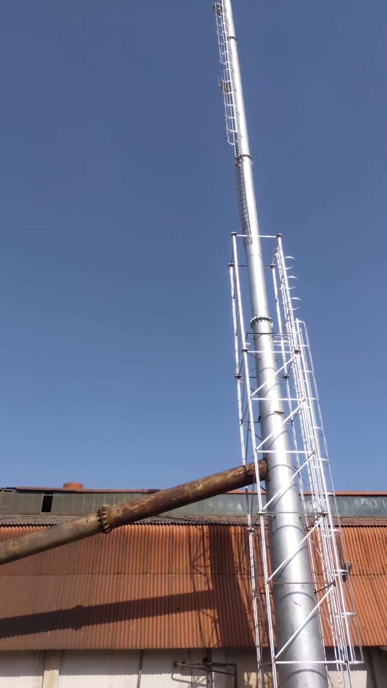 Tall chimney stack with lattice support and caged ladder